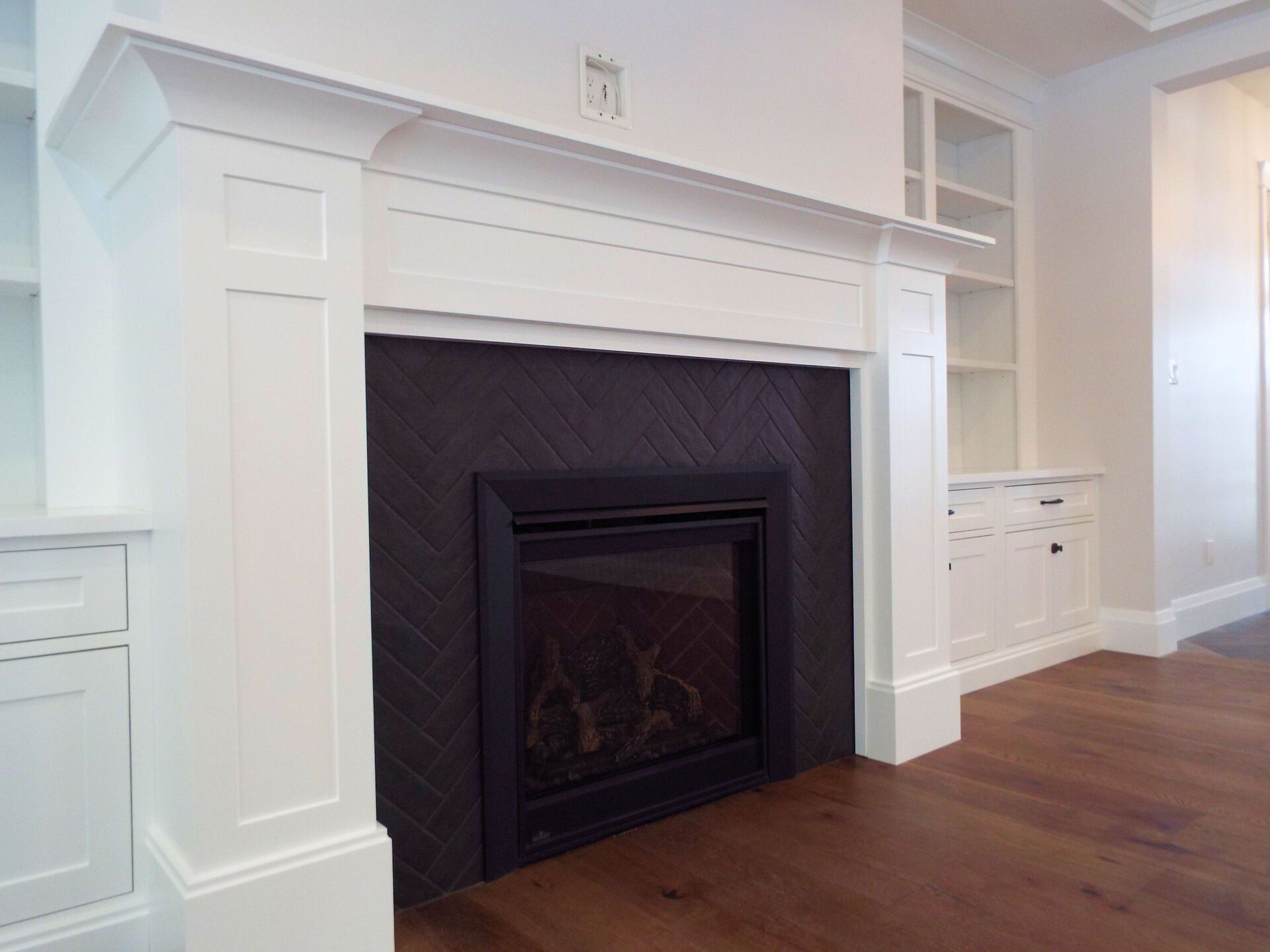 A living room with a fireplace and white cabinets