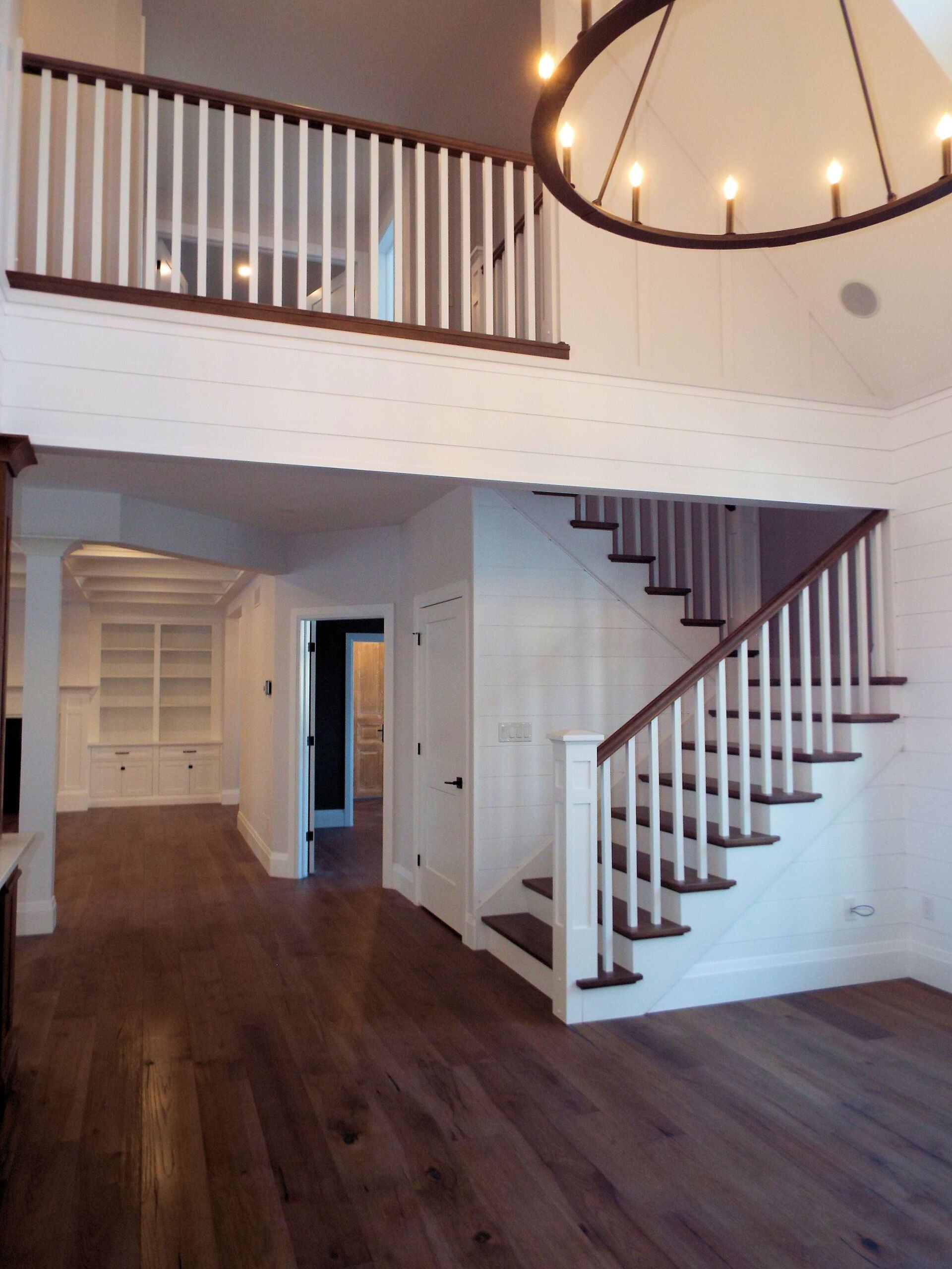 An empty room with a staircase and a chandelier