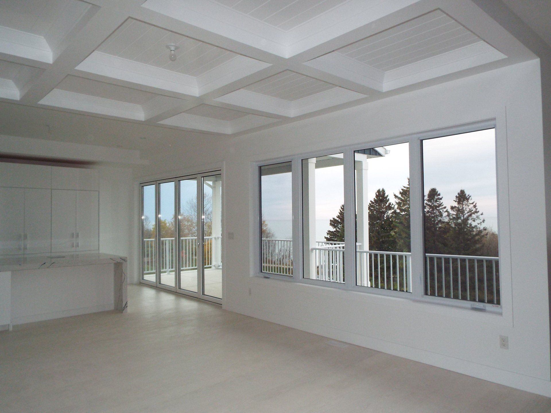 An empty room with lots of windows and a balcony