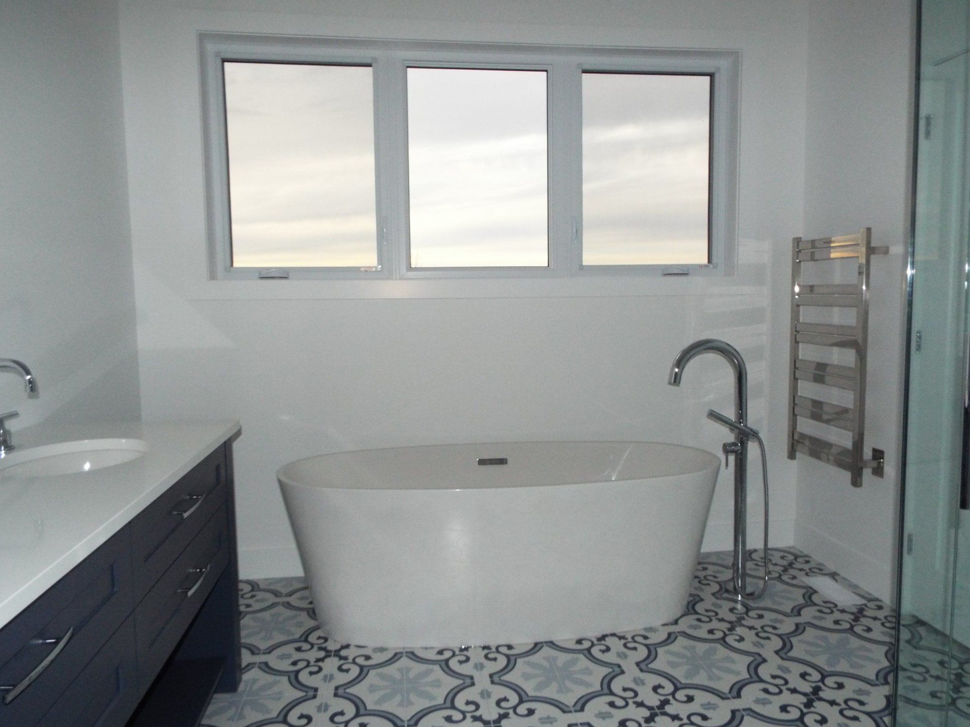 A bathroom with a bathtub , sink , and window.