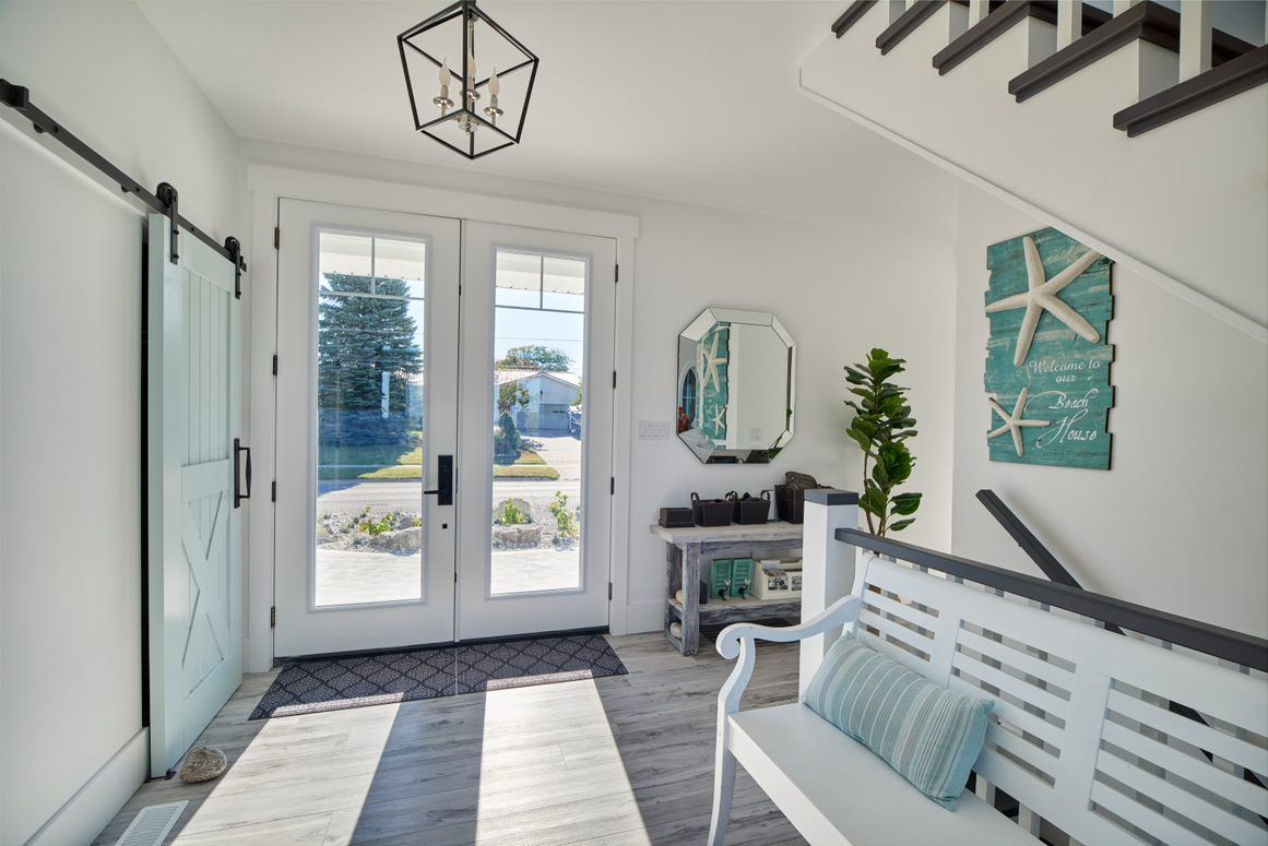 A hallway with a bench and stairs in a house.