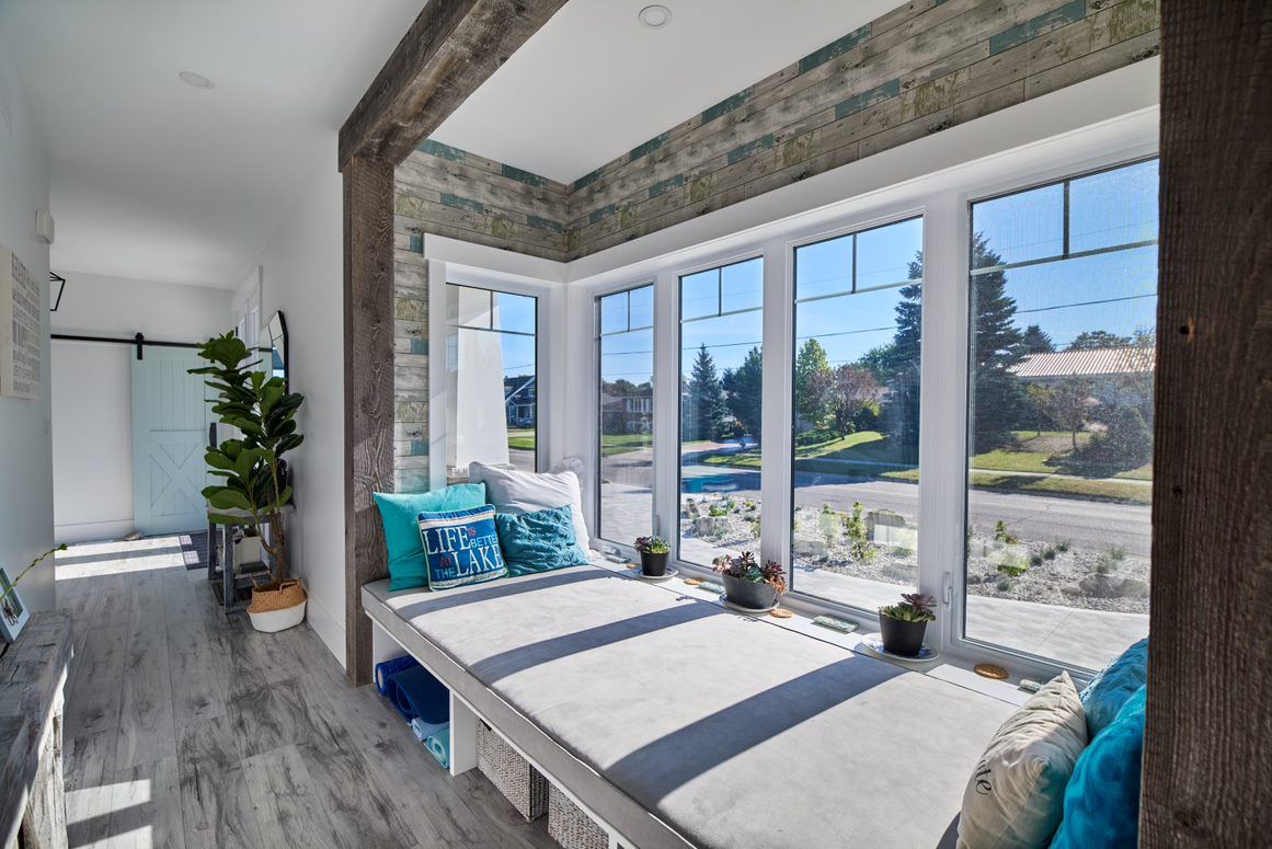 A living room with a bench in front of a window.