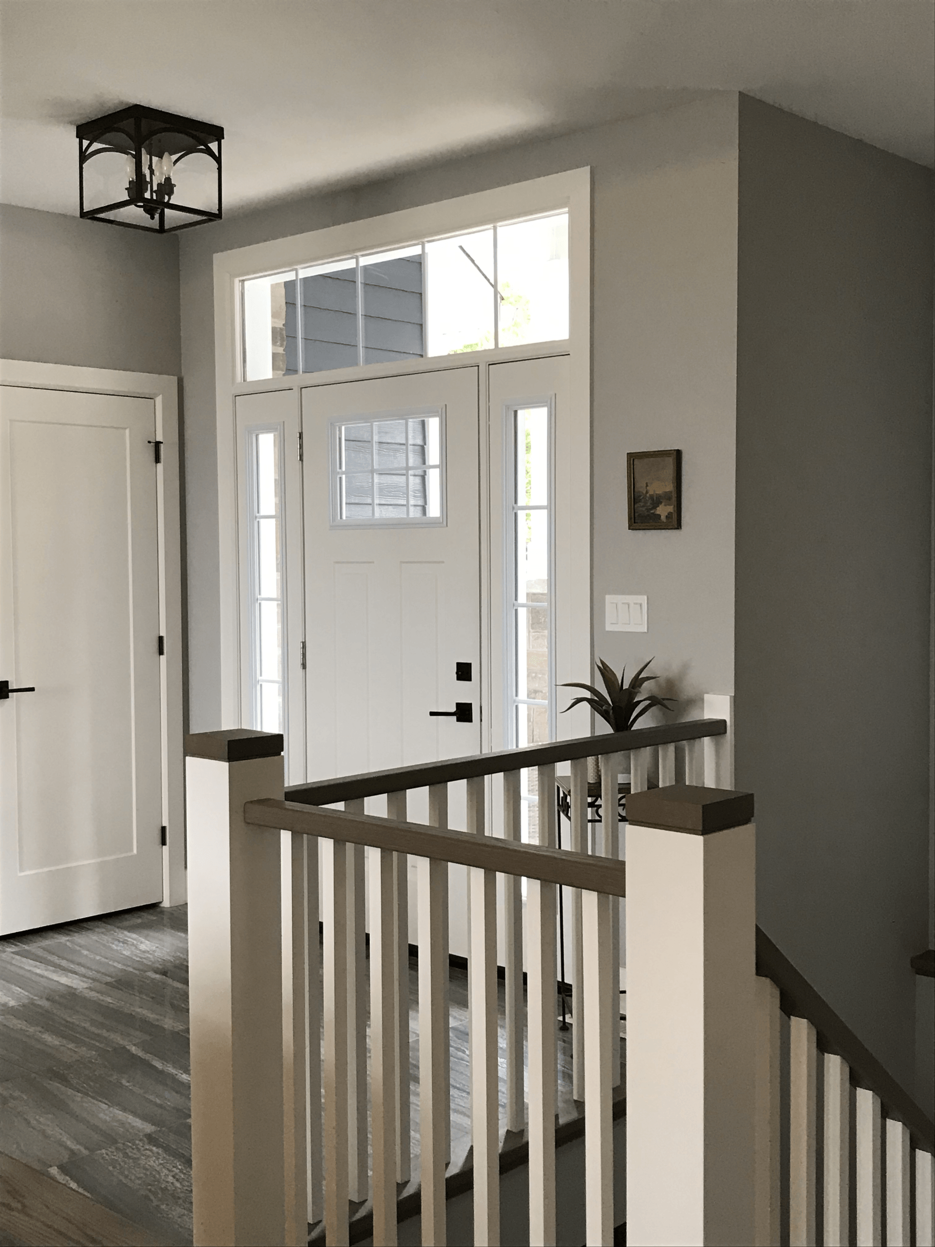 A hallway with a staircase and a white door