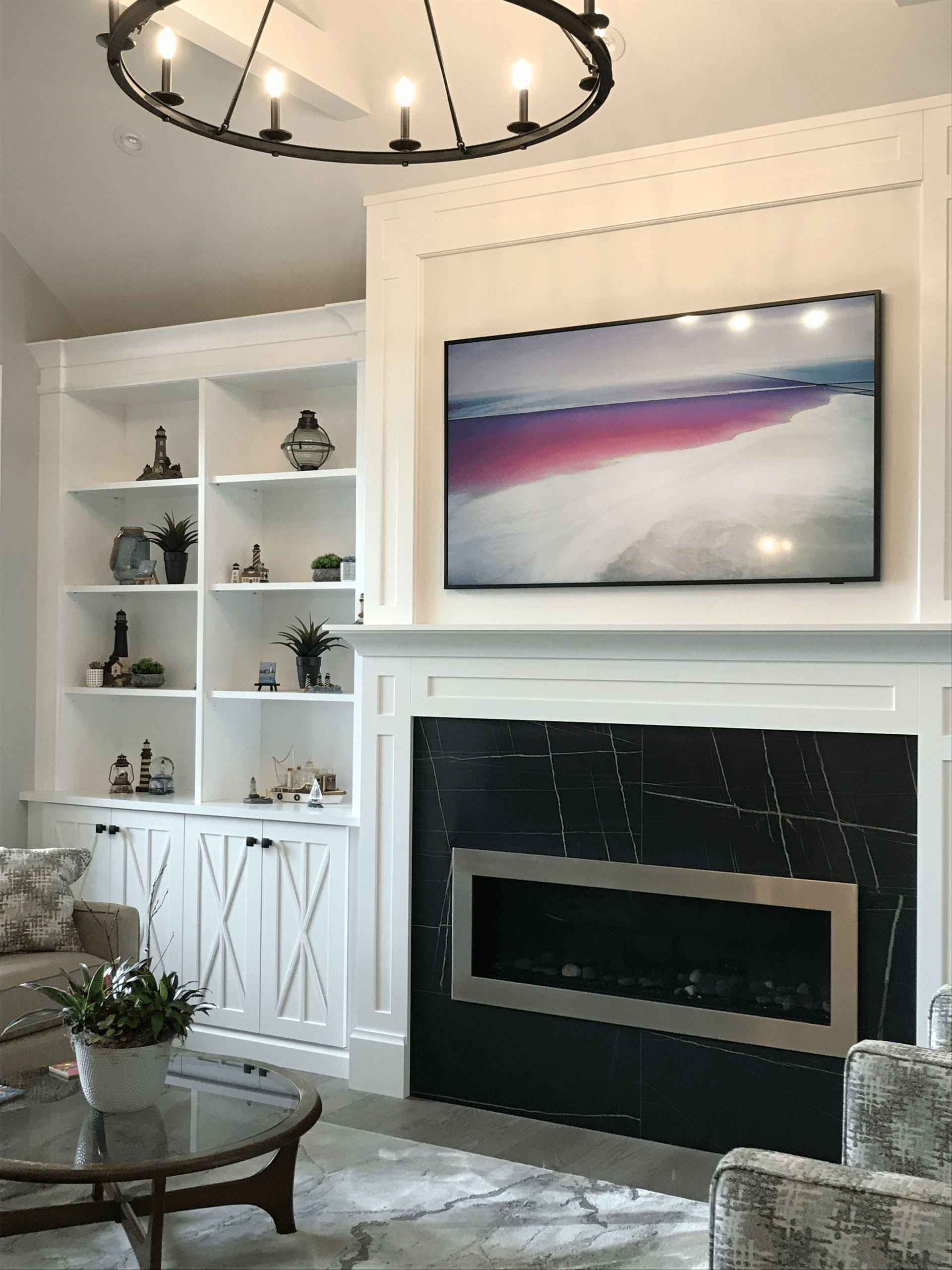 A living room with a fireplace and a flat screen tv on the wall.