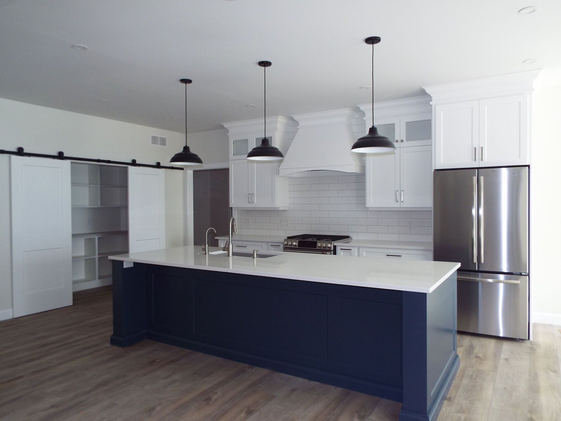 A kitchen with white cabinets and stainless steel appliances