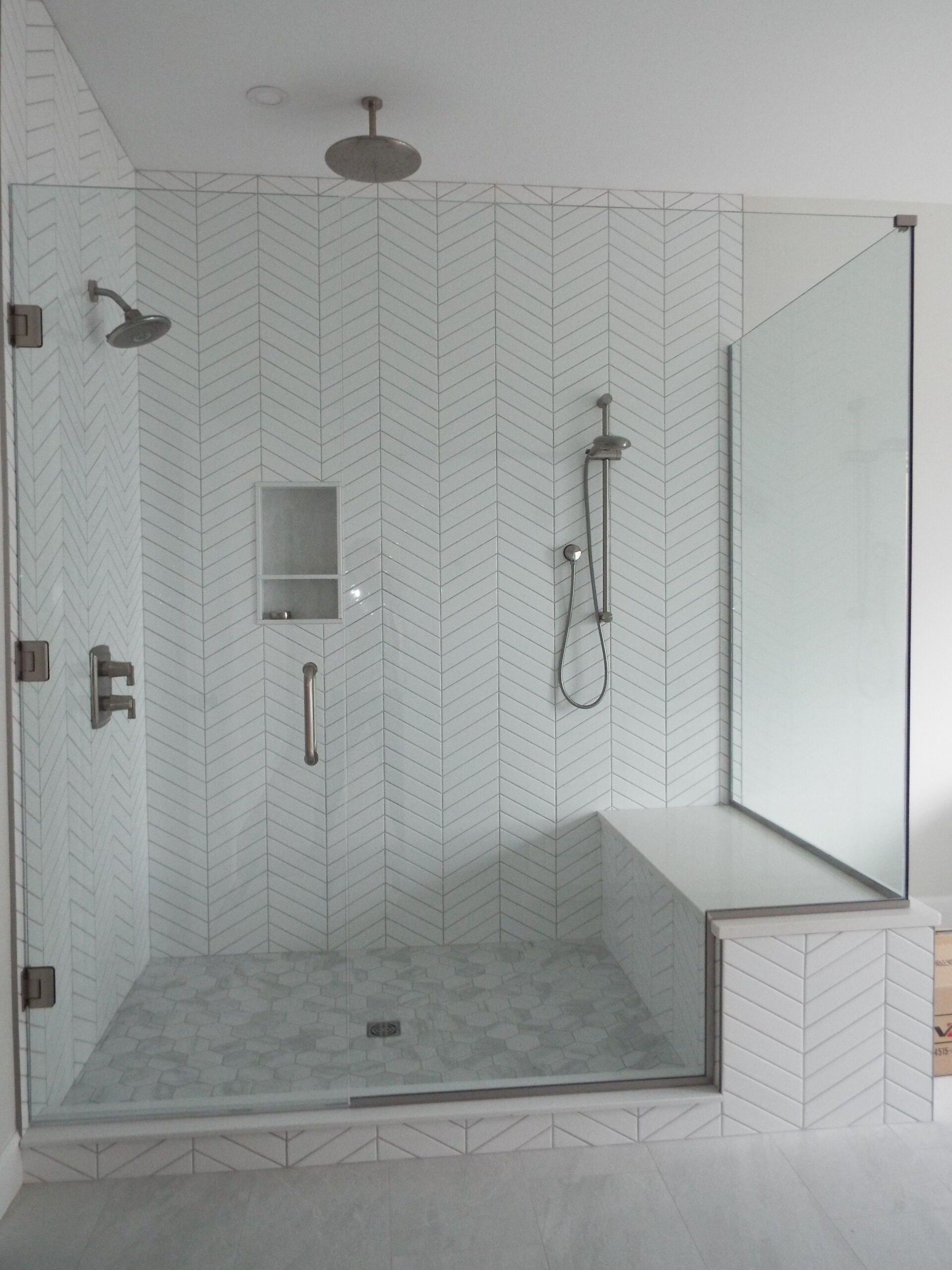A shower with a bench and a shower head