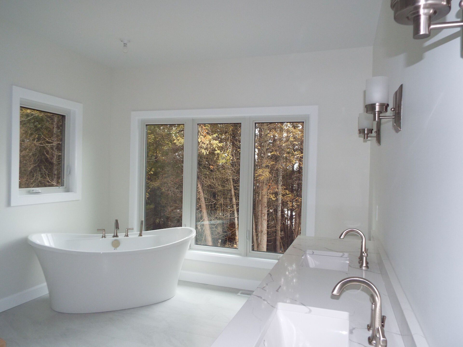 A bathroom with a bathtub and two sinks