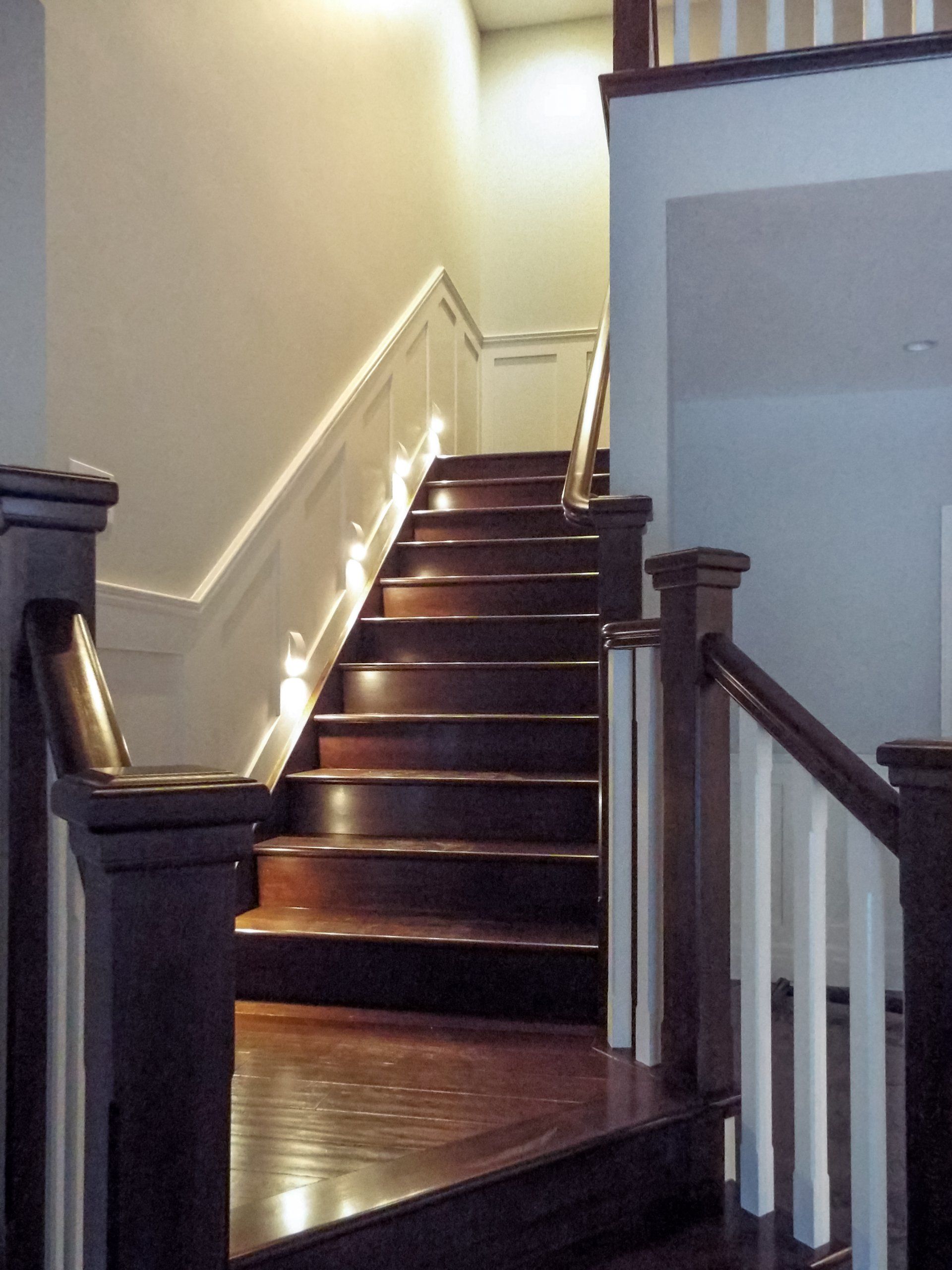A set of wooden stairs with a white railing