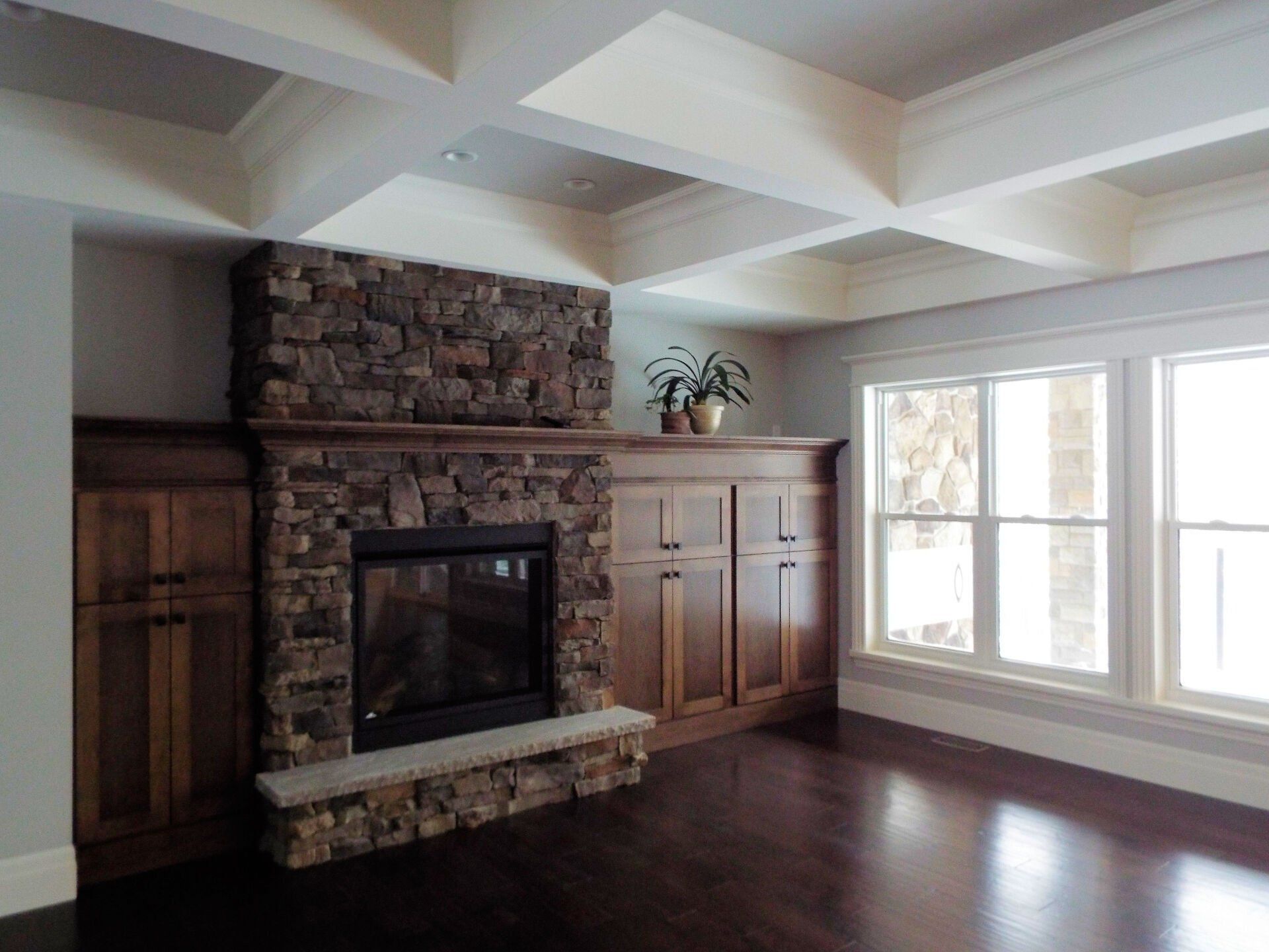 A living room with a fireplace and lots of windows