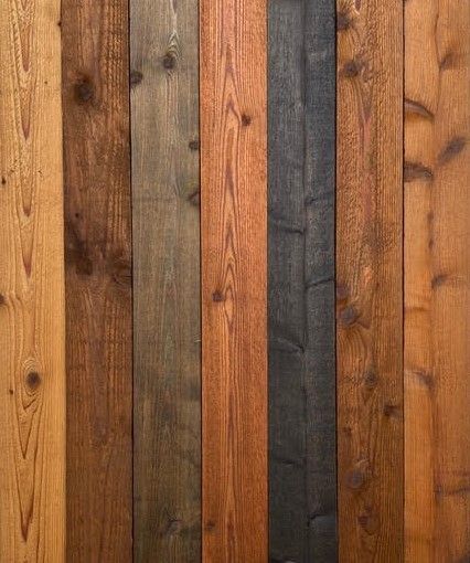 Vertical wooden planks in varied brown, tan, and dark gray tones forming a textured wall pattern