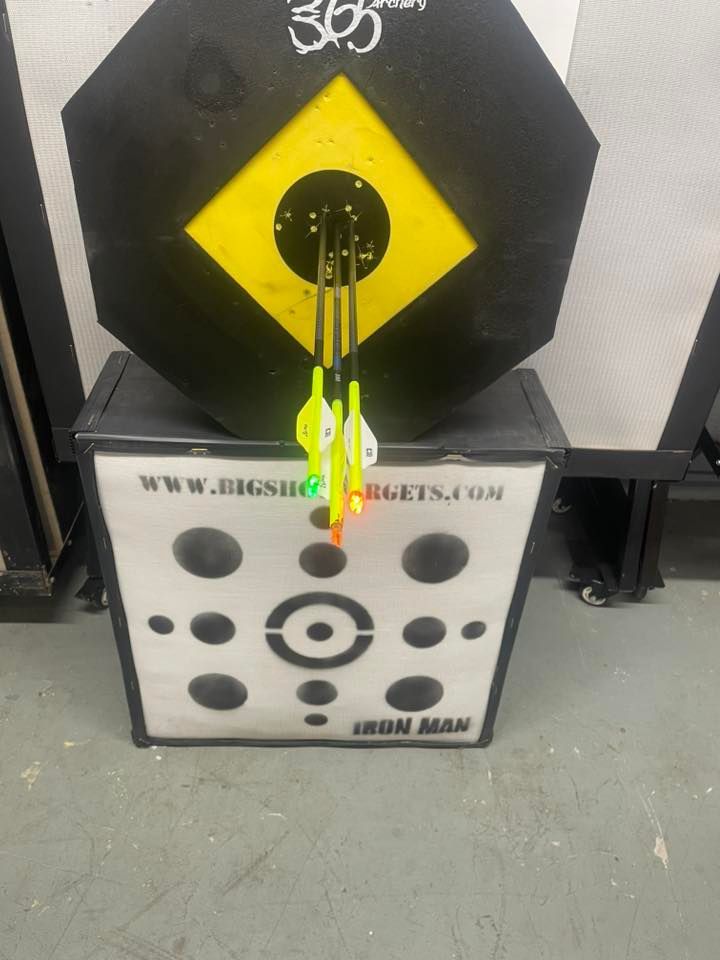 Archery target with three arrows in the yellow center. A second target is below.