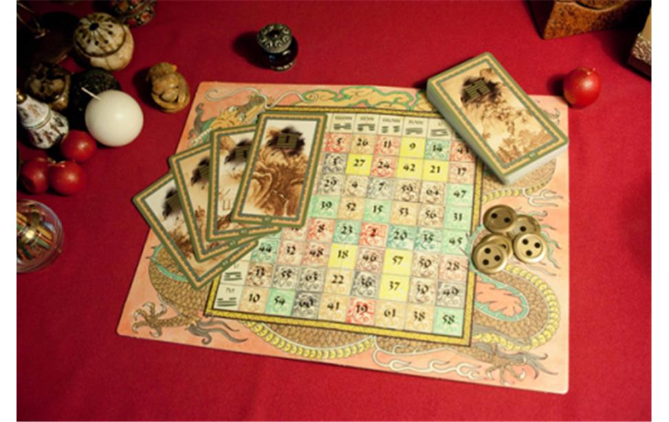 Carte dei tarocchi, una griglia di gioco numerata con immagini di draghi e pedine su un tavolo rosso.