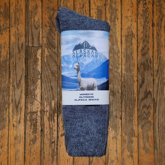 Gray alpaca socks with a label showing an alpaca, mountains, and the words 