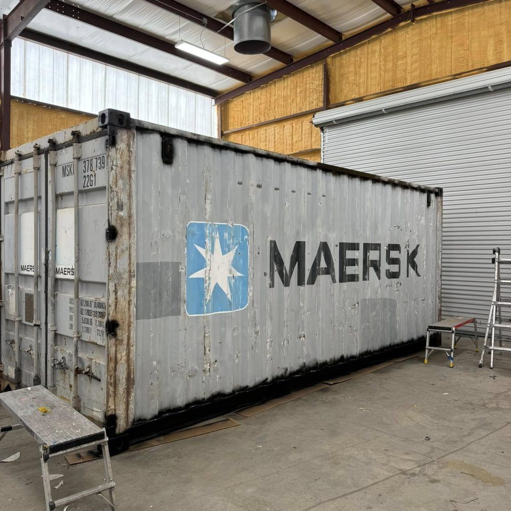 A large shipping container inside a warehouse with a custom 