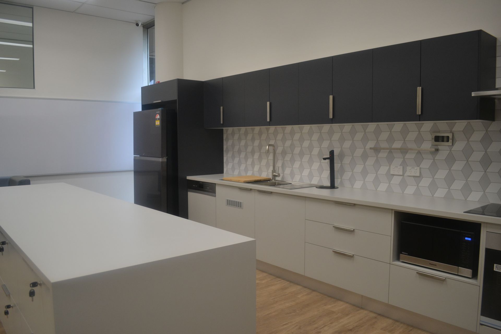 Modern Kitchen With White Island and Black Cabinets — Nick Favot Painting In Bohle, QLD