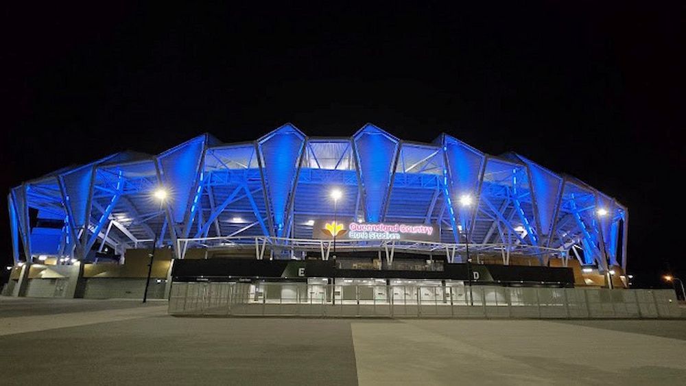 A Large Stadium is Lit Up With Blue Lights at Night — Nick Favot Painting in Bohle, QLD