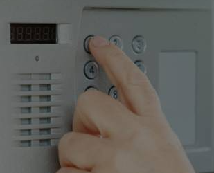 Ask Trusted Fire and Security about our security alarms for managed building access Finger pushing buttons on a security alarm keypad
