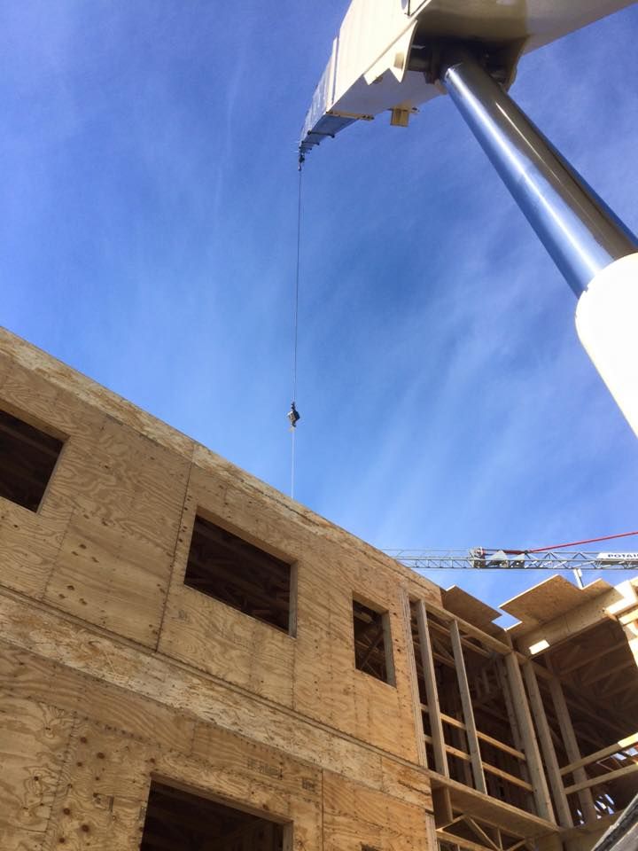 A Vermont Crane Rental from Mayo Crane Rental, LLC assists with a new construction building