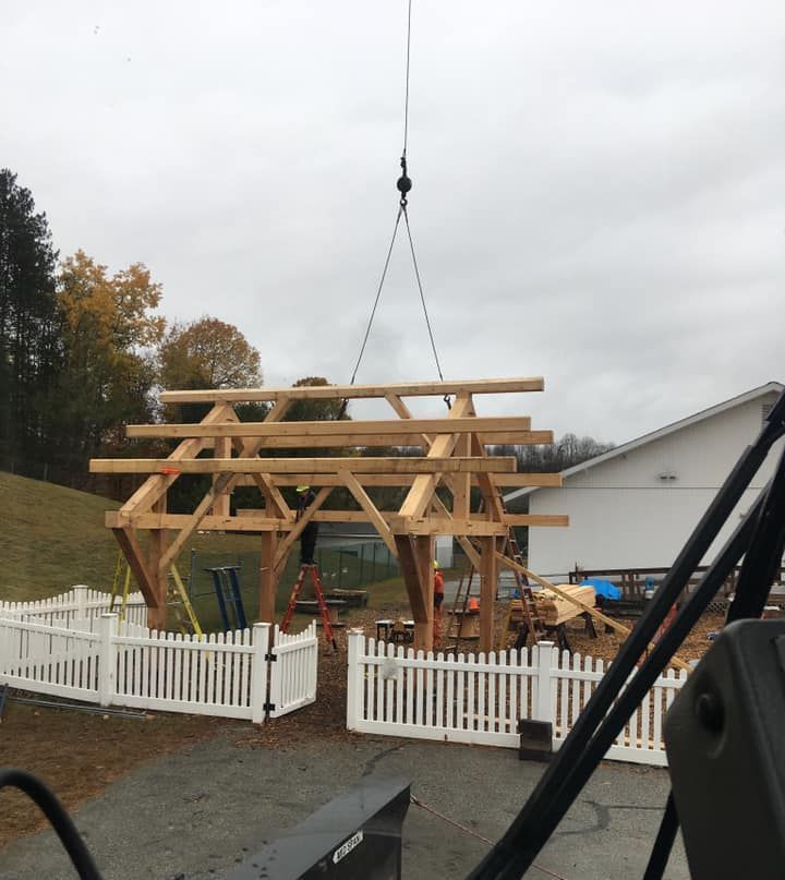 A Vermont Crane Rental lifts a roofing structure