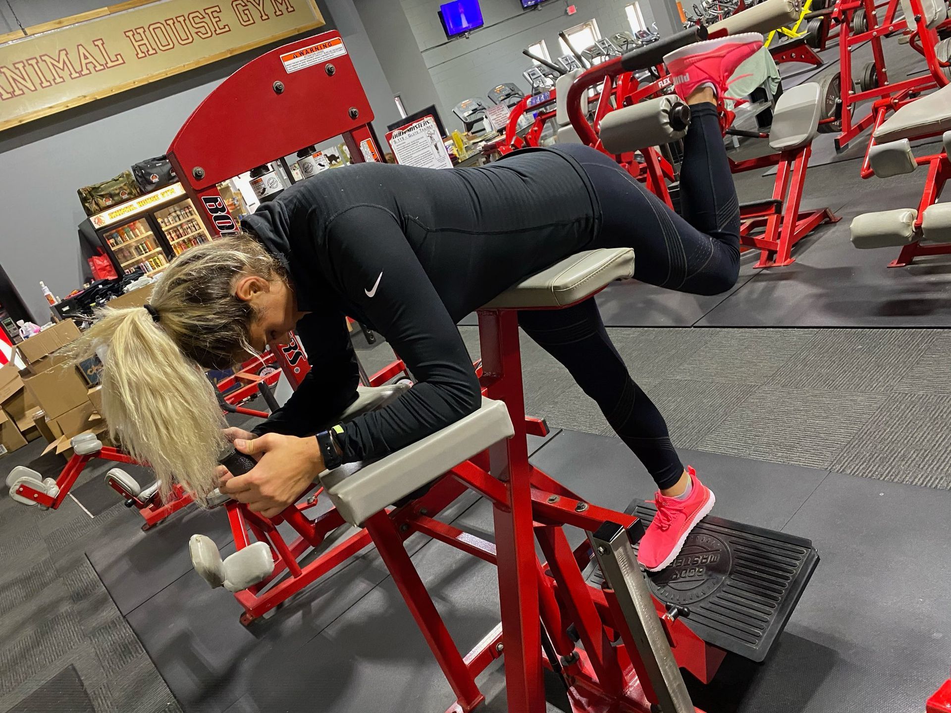 A woman is doing exercises on a machine in a gym.