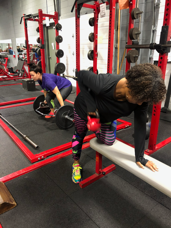 A woman is doing exercises on a bench in a gym.