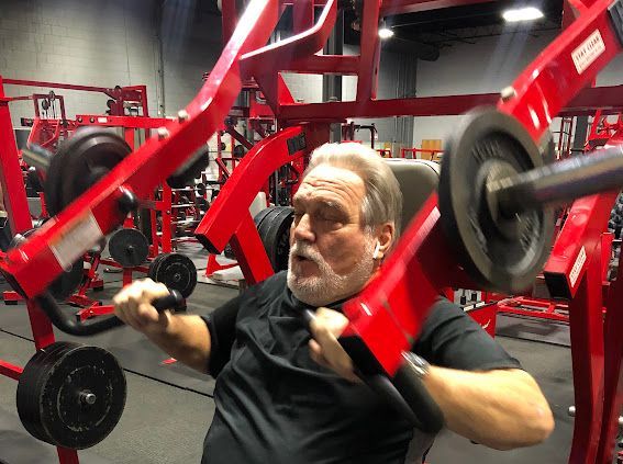 A man is using a machine in a gym.