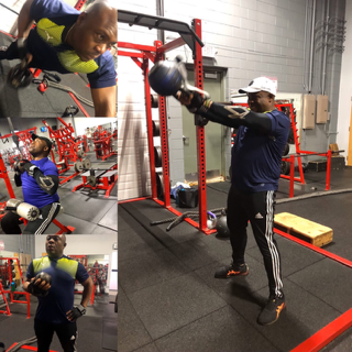 A man in a blue shirt is boxing in a gym
