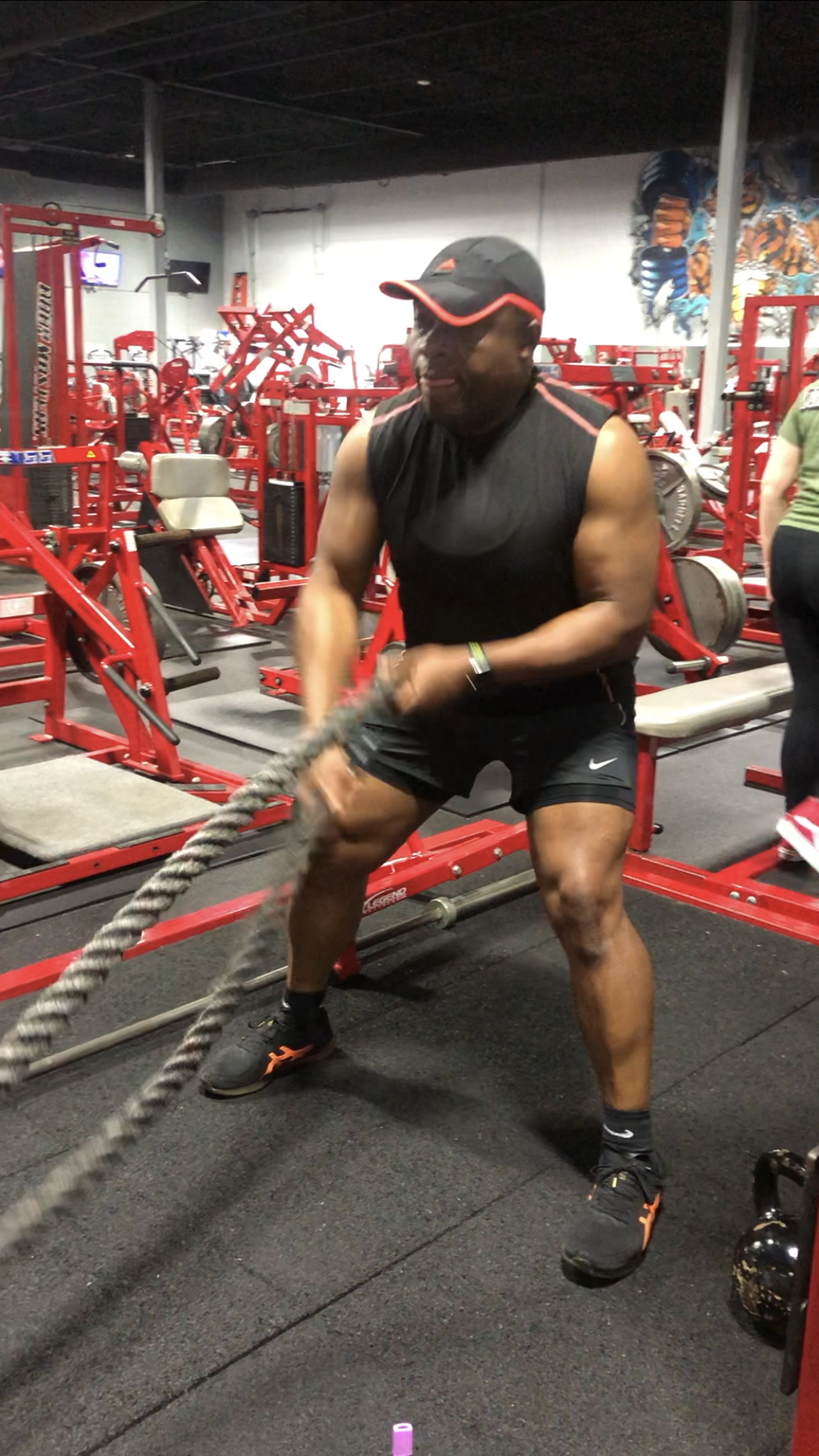 A man is holding a rope in a gym.