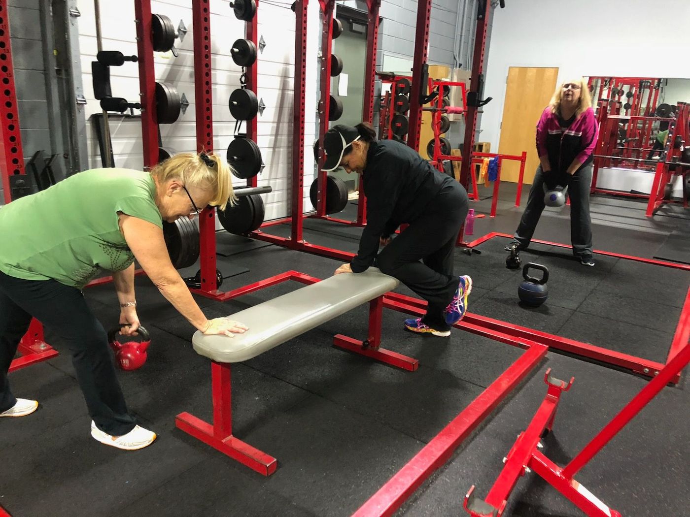 A group of women are doing exercises in a gym.