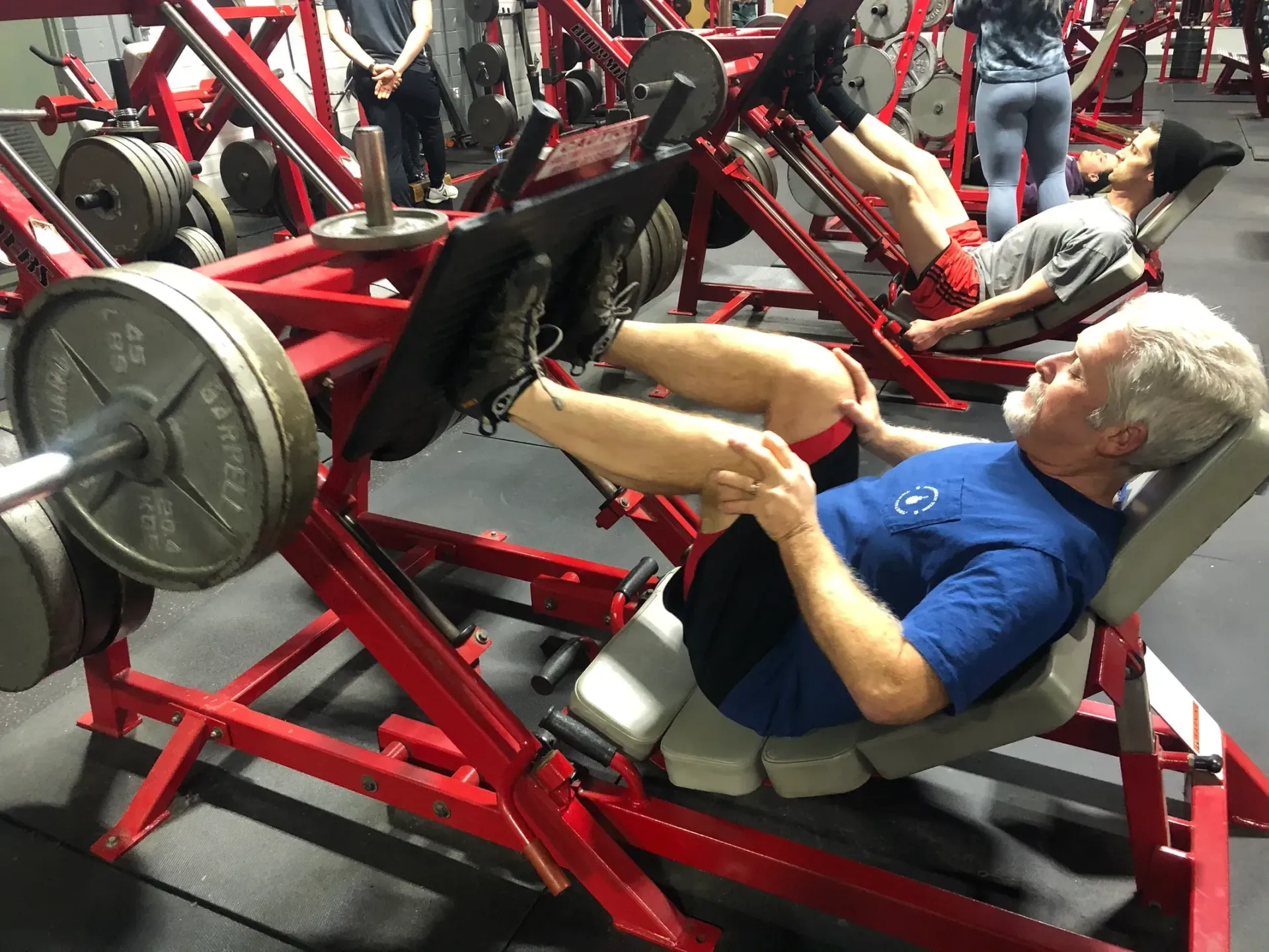 A man is using a leg press machine in a gym.