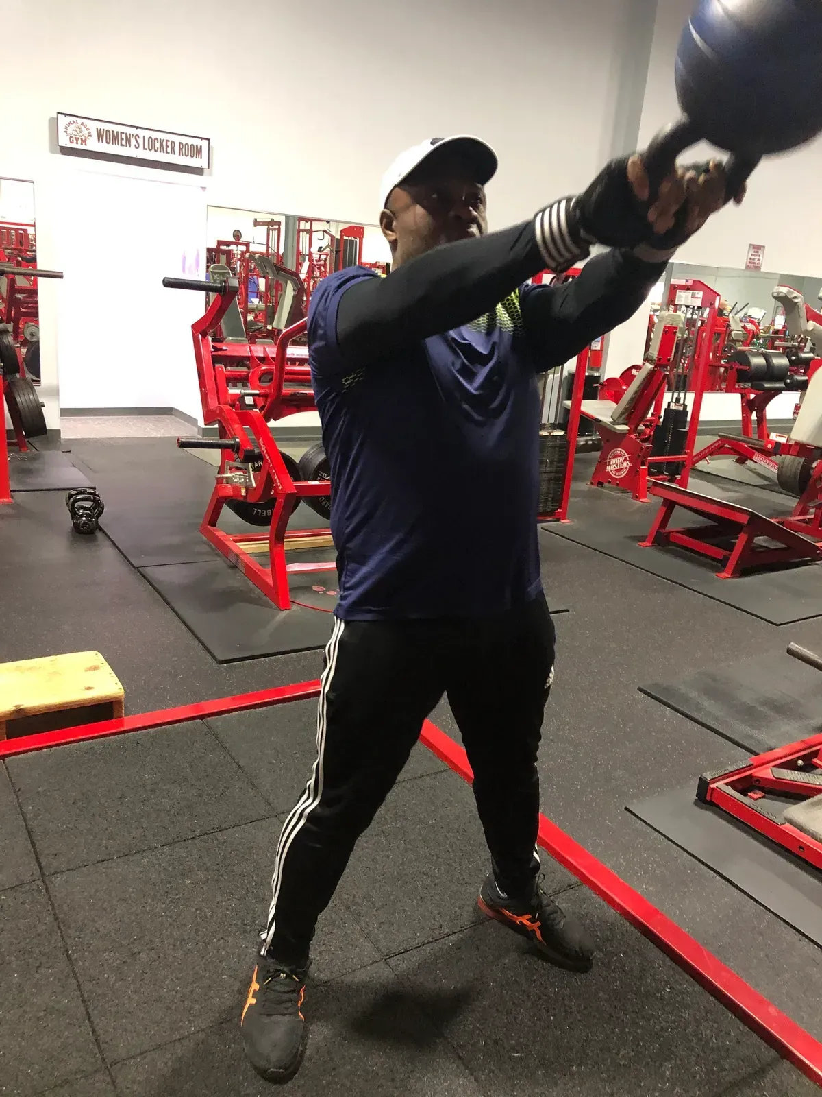 A man is holding a medicine ball in a gym.