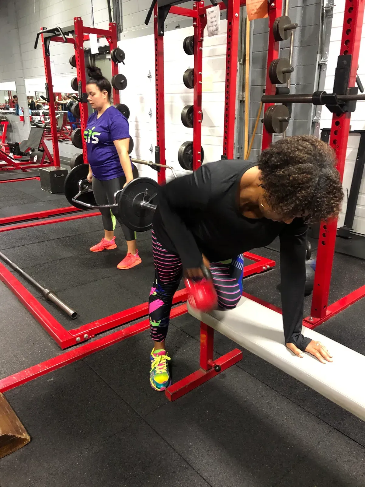 A woman is doing exercises on a bench in a gym.