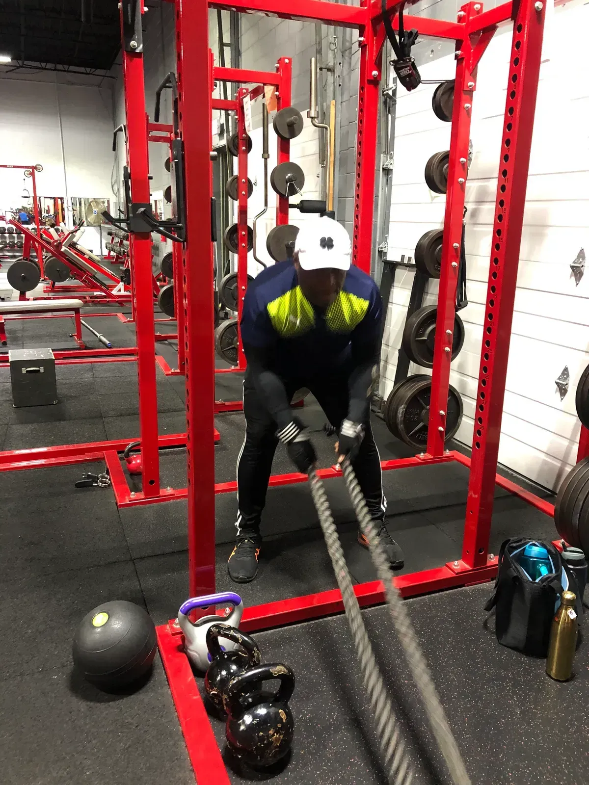 A man is pulling a rope in a gym.