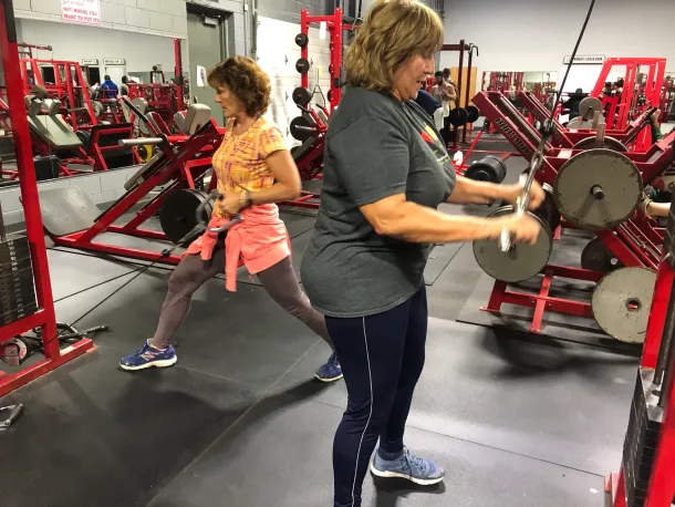 Two women are doing exercises in a gym.