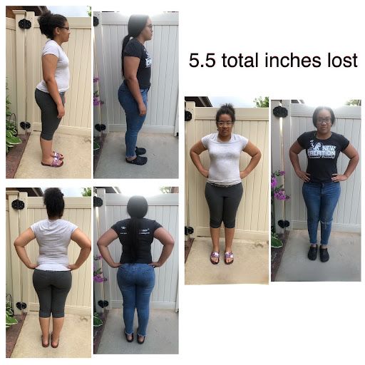 A woman is standing in front of a fence with her hands on her hips.