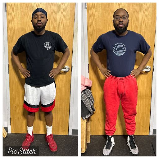 A man is standing in front of a door wearing a black shirt and red sweatpants.