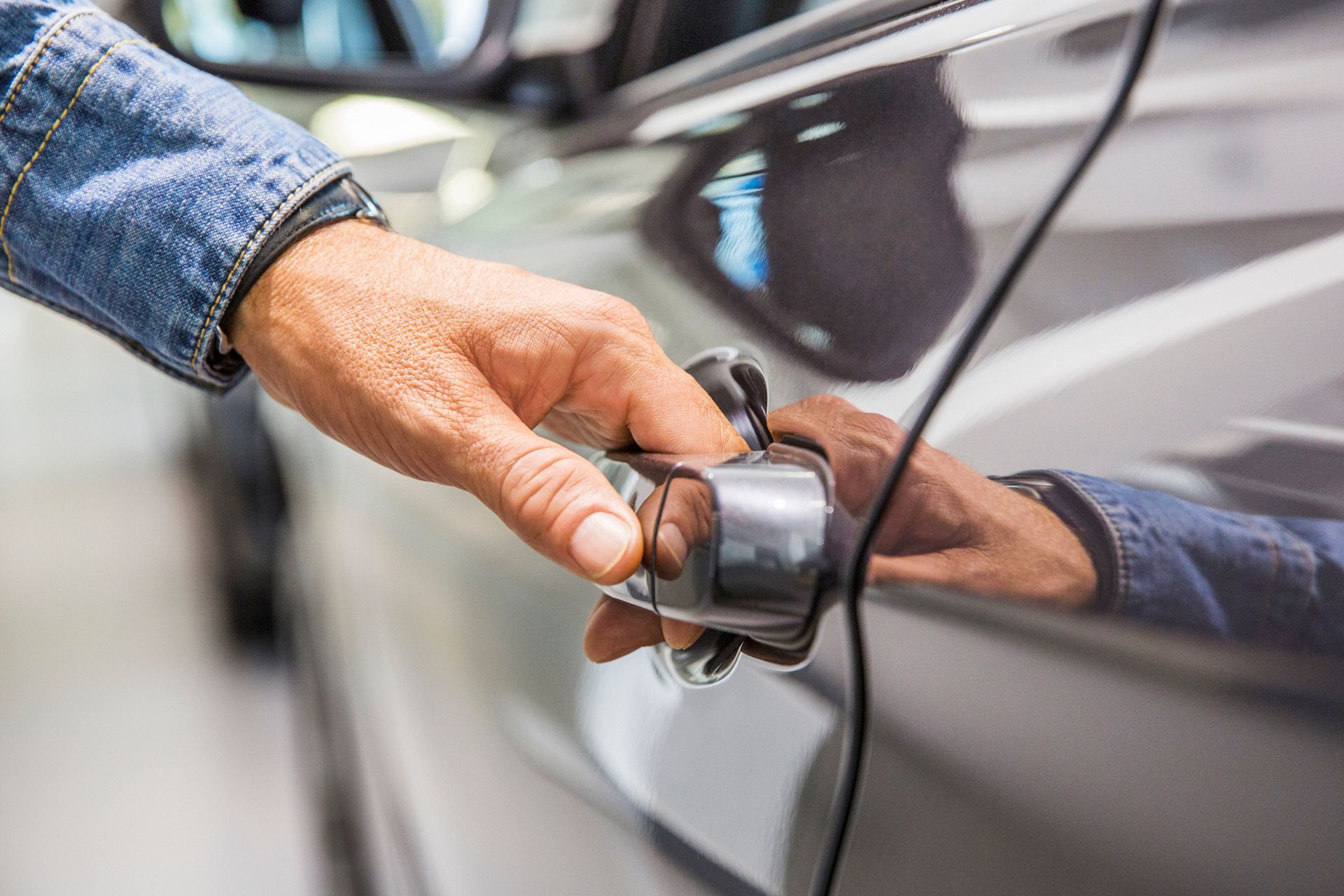 Man's hand reaching for grey car door handle, representing car lockout situation | American Fork, UT Man's hand reaching for grey car door handle, representing car lockout situation | American Fork, UT