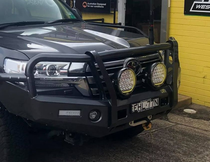 A Black Suv With a Black Bumper is Parked in Front of a Yellow Building — Westlakes 4x4 Centre in Singleton, NSW