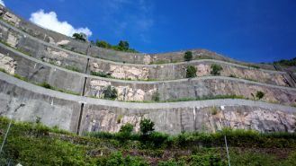 Naturally sloped land in a residential property with concrete retaining wall in Frankston VIC to prevent the soil from erupting.