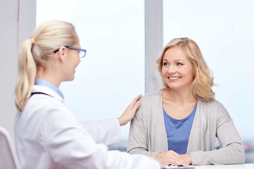 Doctor speaking with a smiling patient in a bright clinic office