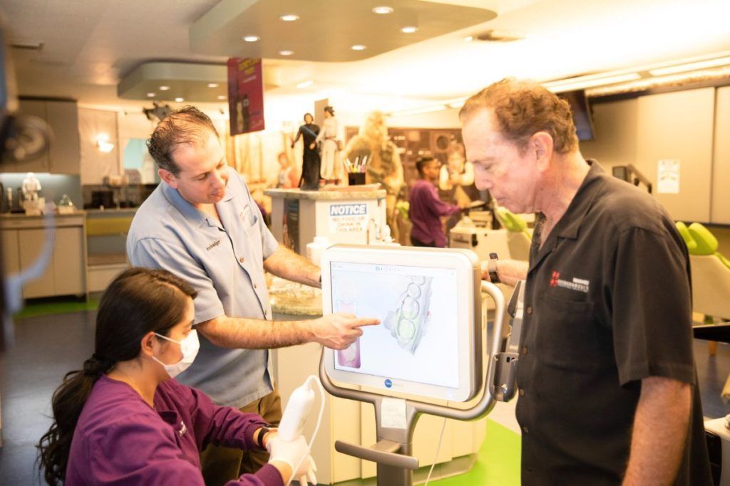 Two people discuss a chart on a touchscreen kiosk in a bright indoor exhibition space