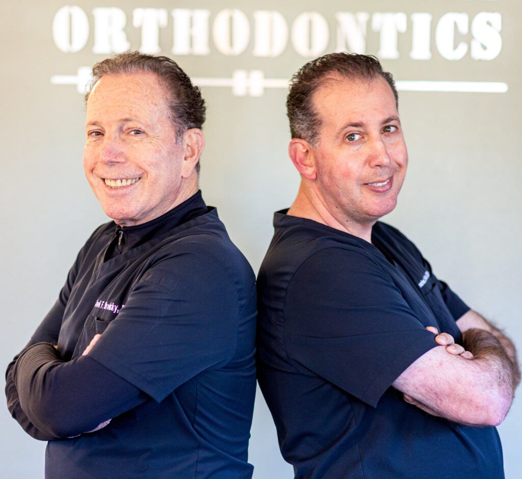 Two side-by-side portrait shots of a person in a black shirt, arms crossed, in front of an orthodontics sign.