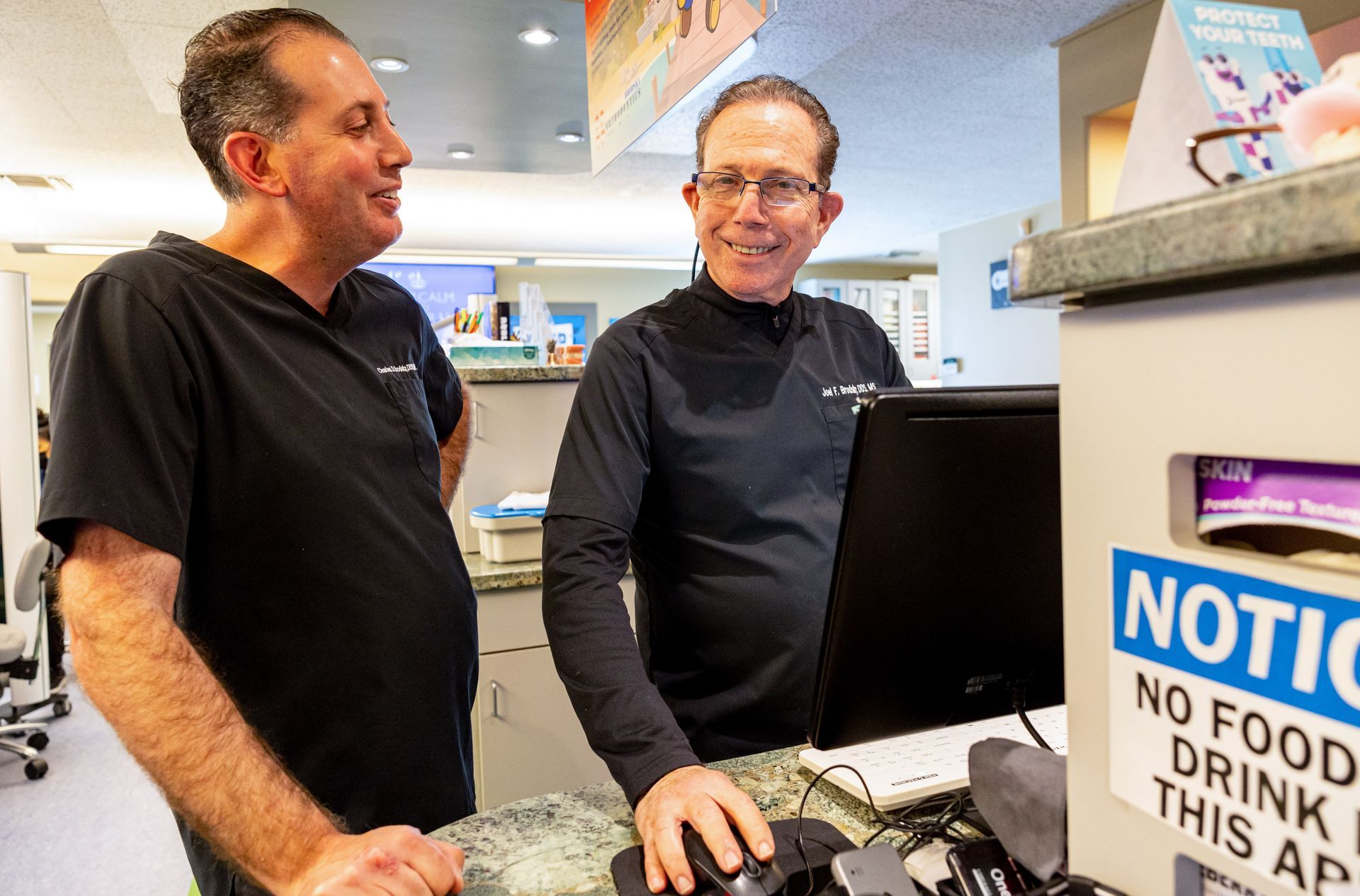 Dr. Joel Brodsky and Dr. Charles Brodsky examining a patient together at Brodsky Orthodontics in Lakewood