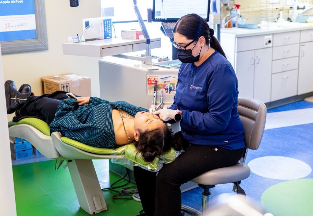 Dentist examining a patient reclined in a chair in a bright dental clinic