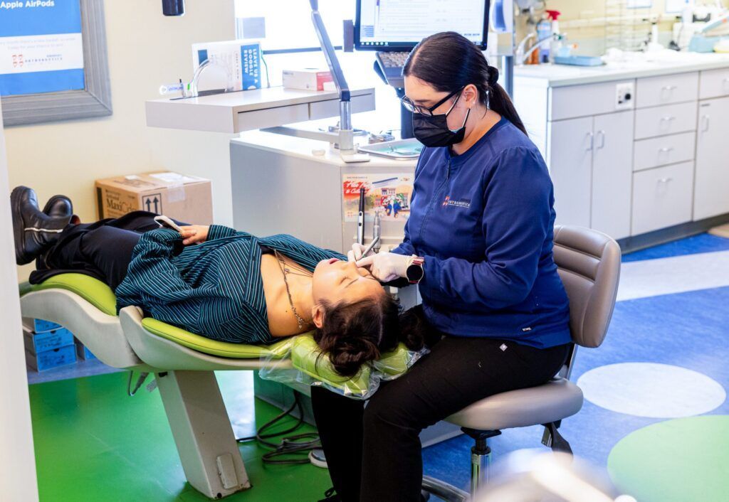 Dentist examining a patient reclining in a dental chair in a clinic
