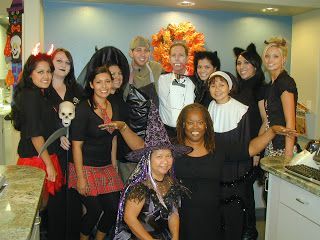Group of people in Halloween costumes posing together in a kitchen indoors