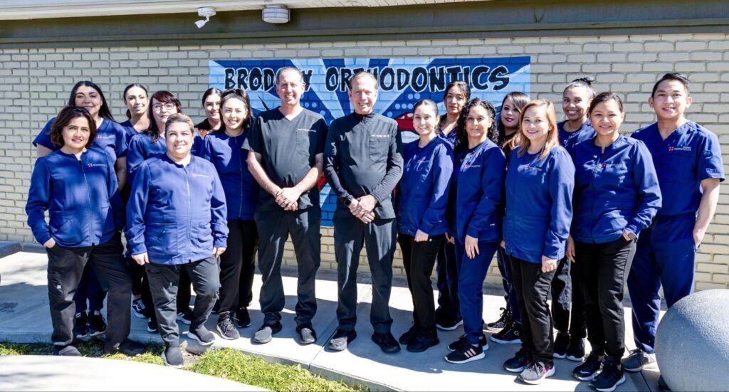 Group of people in blue jackets standing outside a building with a “Robotics” sign