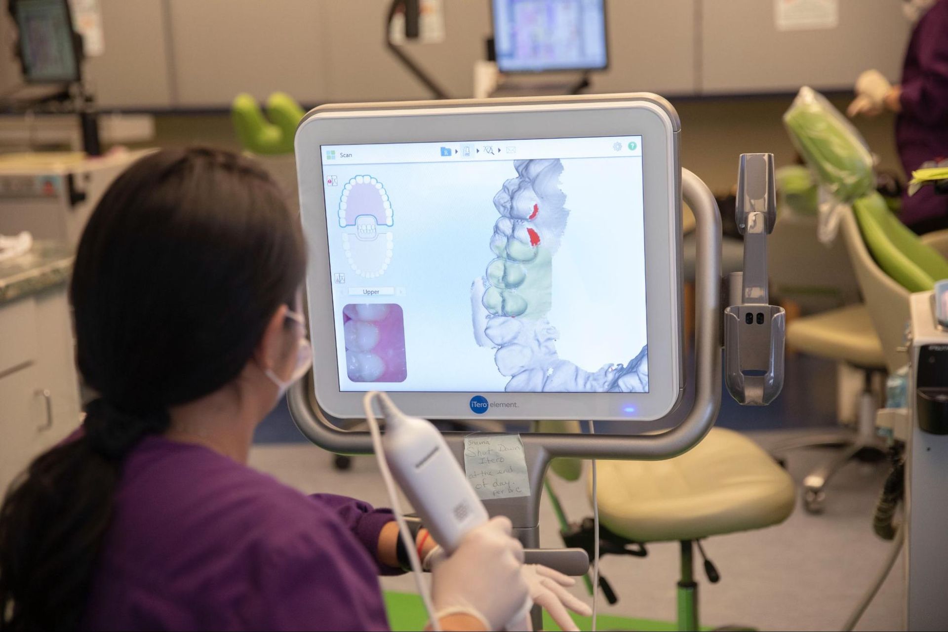 Clinician viewing a 3D spine model on a medical monitor in a clinic office