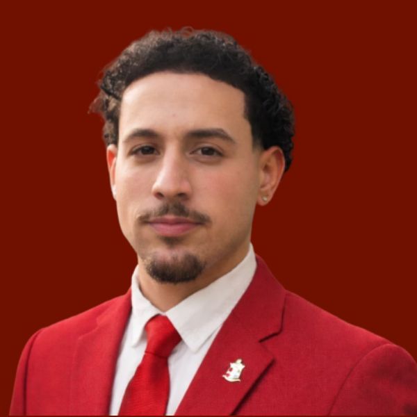 Smiling young Black man in red suit and tie.