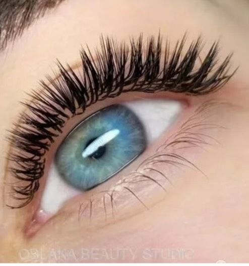 A close up of a woman 's eye with long eyelashes
